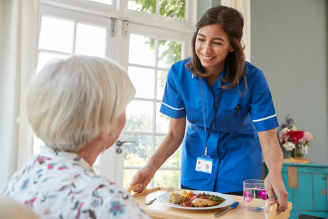woman caregiver serving a food to her patient