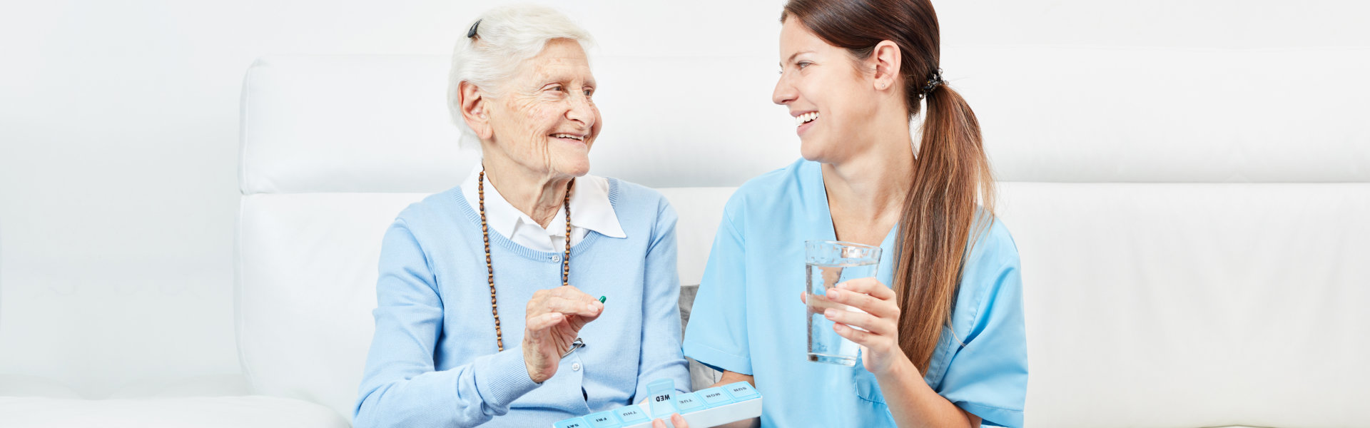 nurse giving medicine to elderly woman
