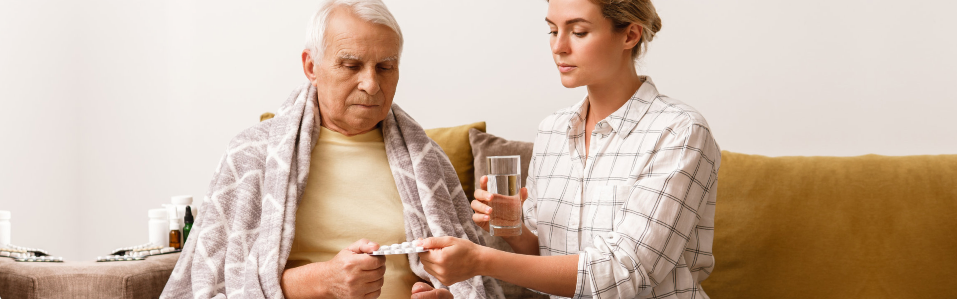 caregiver giving medicine to the elderly