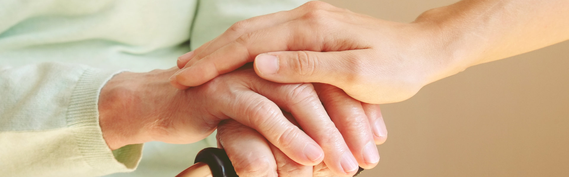 caregiver holding hands with an elderly